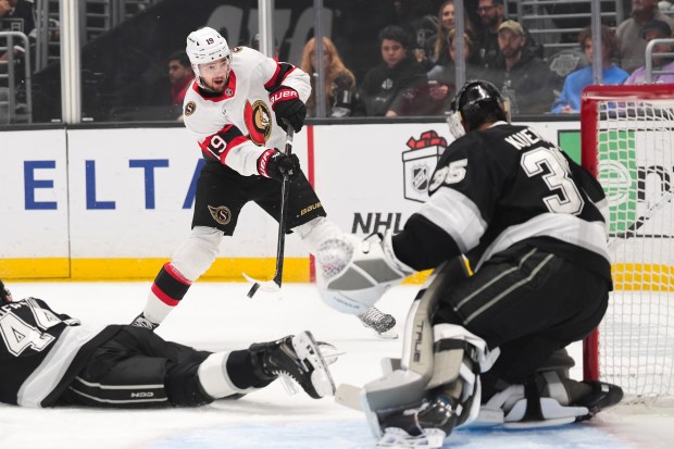 Kings goaltender Darcy Kuemper, right, makes a save against Ottawa...