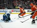 Vancouver Canucks goaltender Nikita Tolopilo (60) stops the shot by Anaheim Ducks defenceman Jackson Lacombe (2) during the first period