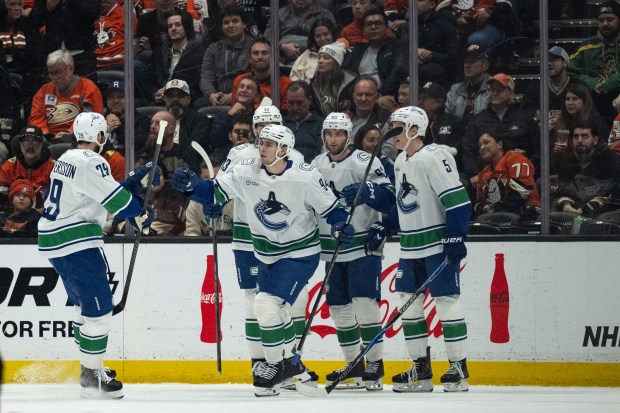 Vancouver Canucks players celebrate a goal by center Linus Karlsson...