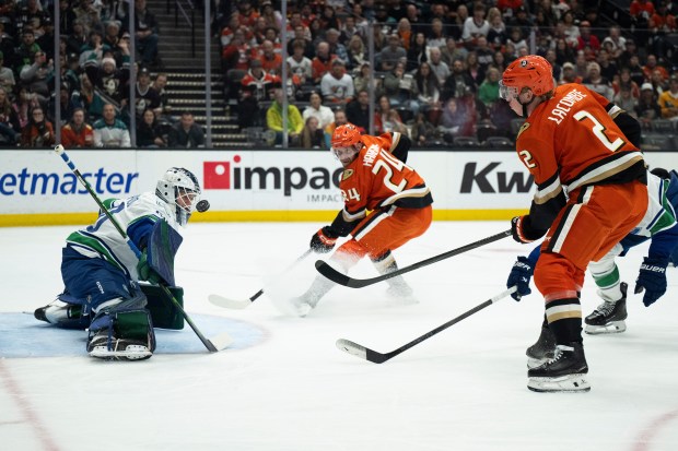 Vancouver Canucks goaltender Nikita Tolopilo, left, blocks a shot by...