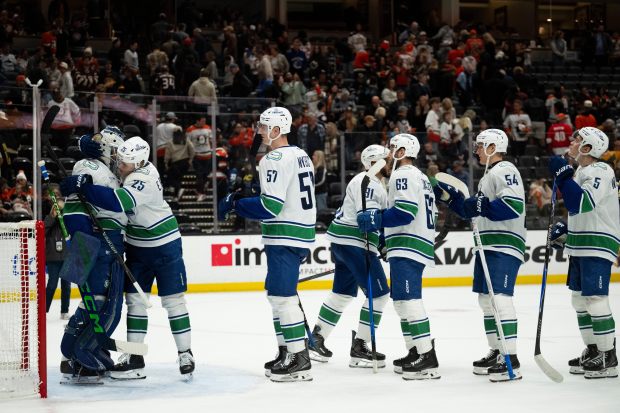 Vancouver Canucks players celebrate the team’s 5-4 victory over the...