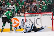 Dallas Stars left wing Jason Robertson, left, scores a goal on Utah Hockey Club goaltender...