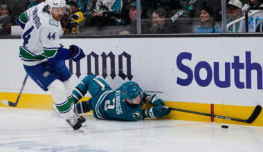 San Jose Sharks defenseman John Klingberg (3) falls on the ice as Vancouver Canucks left wing Kiefer Sherwood (44) chases after the puck during the second period of an NHL hockey game, Friday, Nov. 28, 2025, in San Jose, Calif. (AP Photo/Godofredo A. V&aacute;squez)