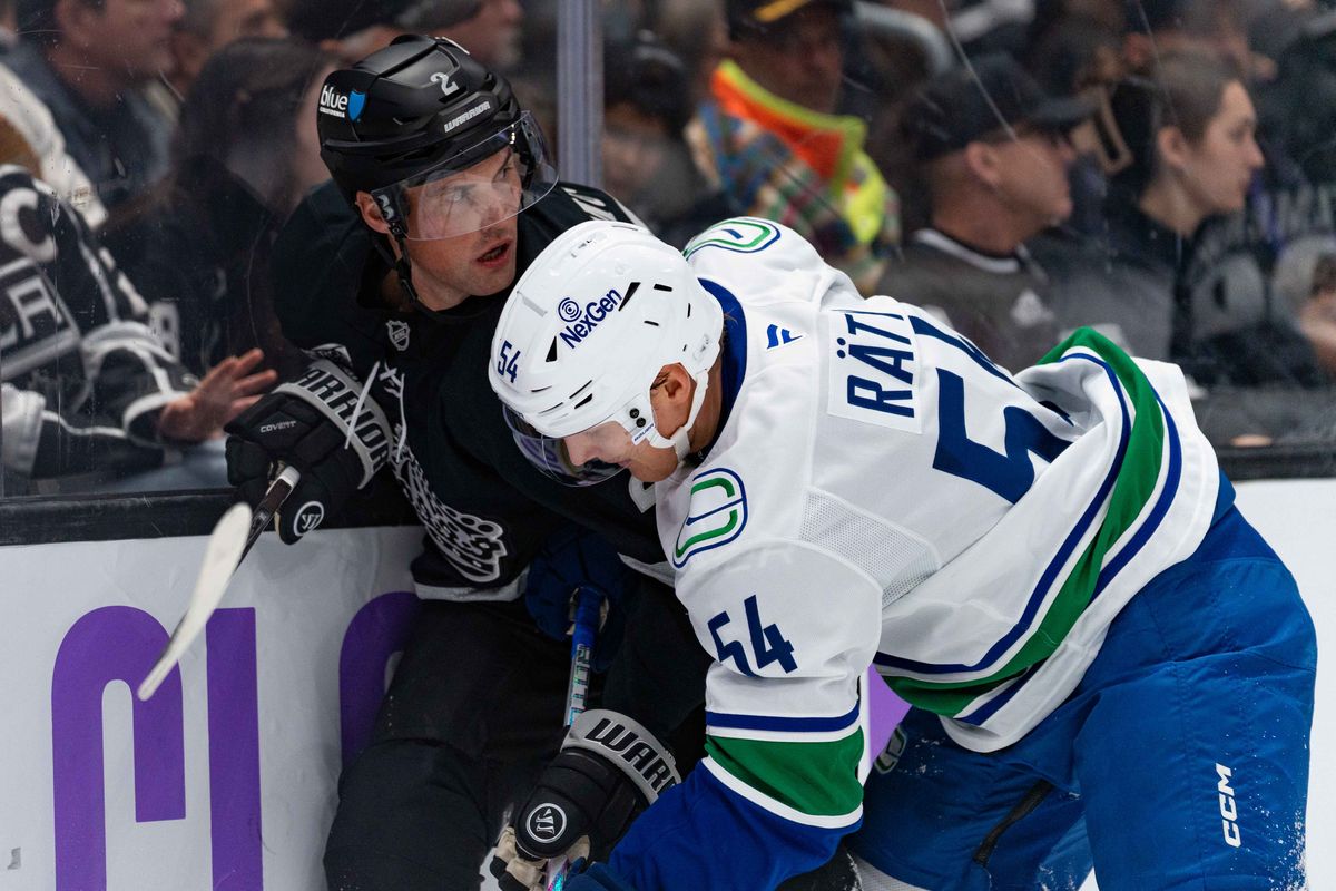 Los Angeles Kings defenseman Brian Dumoulin (2) fights with Vancouver Canucks center Aatu Raty (54) for the puck during an NHL game between the Vancouver Canucks and the Los Angeles Kings, Saturday November 29, 2025 at Crypto.com Arena in Los Angeles, Calif.