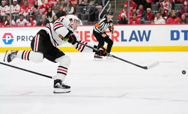 Chicago Blackhawks center Oliver Moore shoots during the first period of an NHL hockey game against the Detroit Red Wings, Sunday, Nov. 9, 2025, in Detroit. (AP Photo/Ryan Sun)
