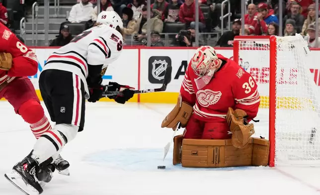 Chicago Blackhawks left wing Tyler Bertuzzi (59) against Detroit Red Wings goaltender John Gibson, right, during the third period of an NHL hockey game Sunday, Nov. 9, 2025, in Detroit. (AP Photo/Ryan Sun)