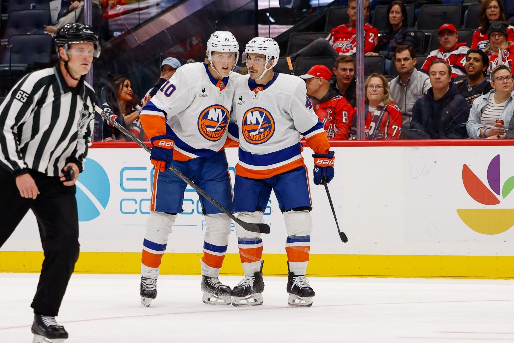 Jean-Gabriel Pageau #44 and Simon Holmstrom #10 of the New York Islanders celebrate a second period goal during a game against the Washington Capitals at Capital One Arena on October 31, 2025 in Washington, D.C. 