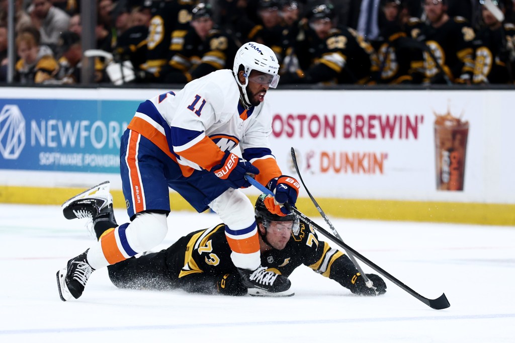 Charlie McAvoy #73 of the Boston Bruins dives for the puck ahead of Anthony Duclair #11 of the New York Islanders during the second period at TD Garden on October 28, 2025 in Boston, Massachusetts.