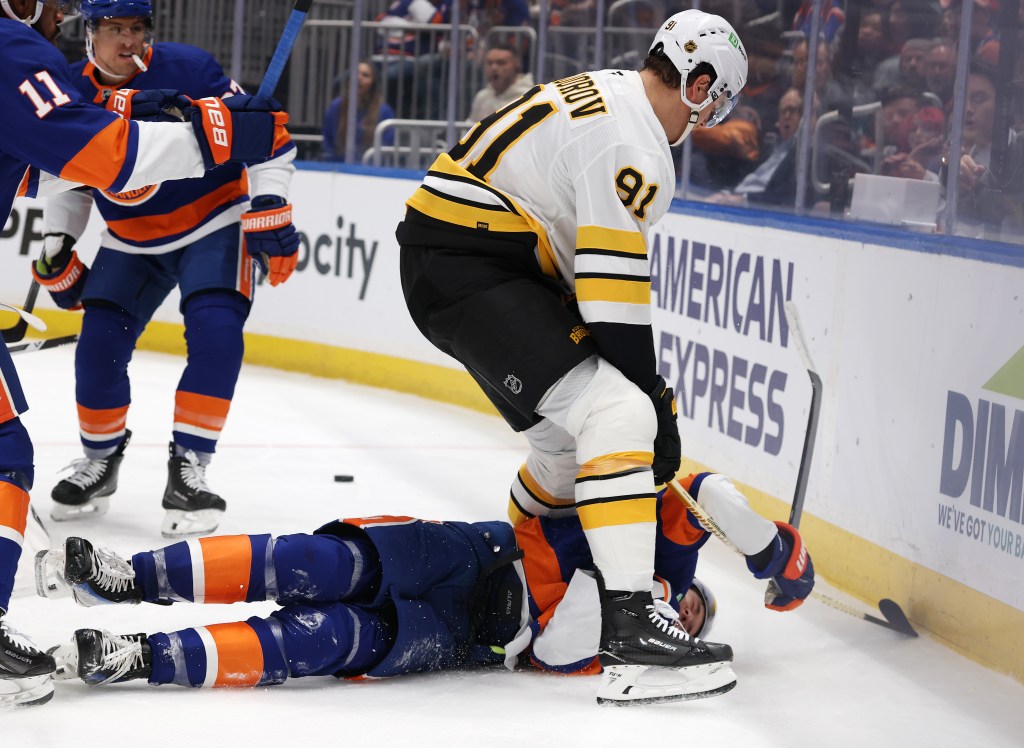 Nikita Zadorov #91 of the Boston Bruins checks Matthew Schaefer #48 of the New York Islanders in the second period during their game at UBS Arena on November 04, 2025 in Elmont, New York.