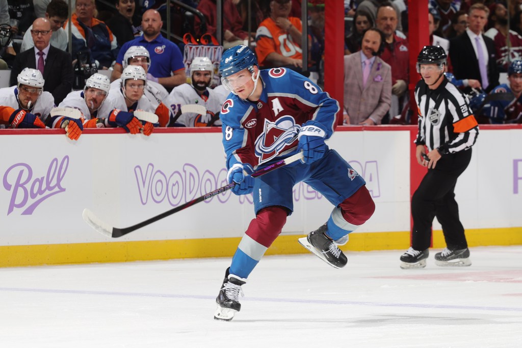 A Colorado Avalanche player skating on the ice with a hockey stick.