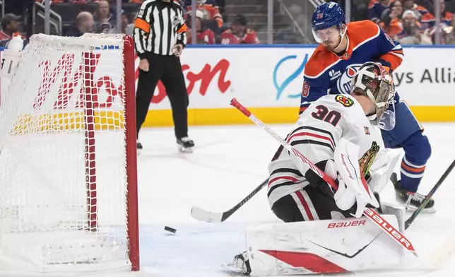 Chicago Blackhawks goalie Spencer Knight (30) is scored on by Edmonton Oilers' Jack Roslovic (28) during second period NHL action, in Edmonton on Saturday, Nov. 1, 2025. (Jason Franson/The Canadian Press via AP)