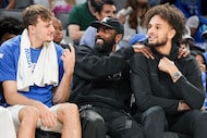 Dallas Mavericks forward Cooper Flagg (from left) laughs on the bench with guard Kyrie...