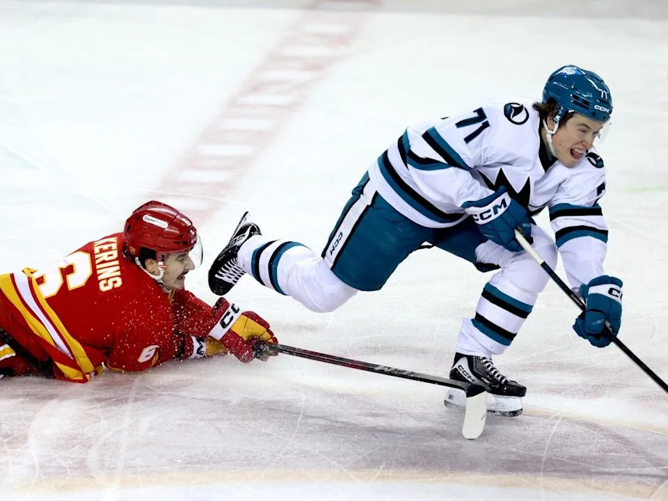  Flames forward Rory Kerins tries to slow Sharks forward Macklin Celebrini on Thursday.