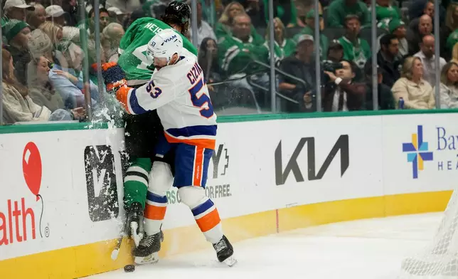 New York Islanders center Casey Cizikas (53) checks Dallas Stars defenseman Miro Heiskanen (4) into the glass during the second period of an NHL hockey game, Tuesday, Nov. 18, 2025, in Dallas. (AP Photo/Gareth Patterson)