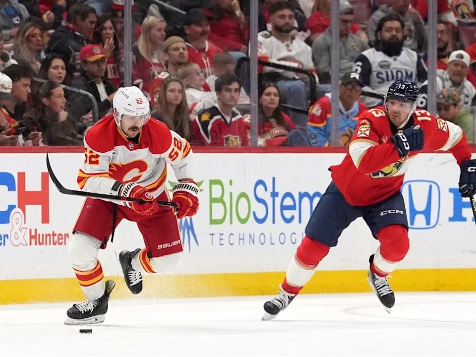  Flames defenceman MacKenzie Weegar skates down ice pursued by Panthers forward Sam Reinhart.