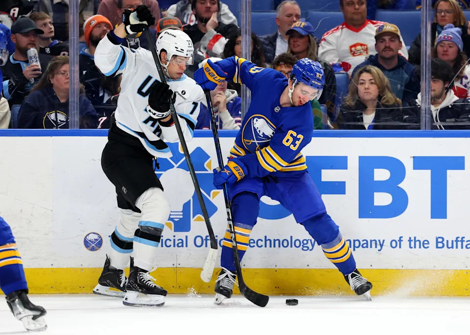 Nov 4, 2025; Buffalo, New York, USA; Utah Mammoth right wing JJ Peterka (77) and Buffalo Sabres right wing Isak Rosen (63) go after a loose puck during the third period at KeyBank Center. (Timothy T. Ludwig-Imagn Images)