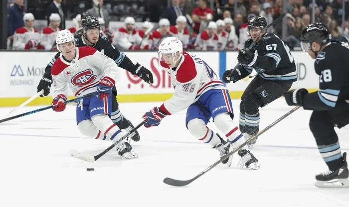  Lane Hutson (#48) and Cole Caufield (#13) of the Montreal Canadiens rush the puck against Lawson Crouse (#67), Ian Cole (#28) and Mikhail Sergachev (#98) of the Utah Mammoth during the first period of their game at the Delta Center on November 26, 2025 in Salt Lake City, Utah.