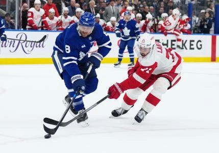 Detroit Red Wings center Dylan Larkin battles for the puck with Toronto Maple Leafs defenseman Chris Tanev
