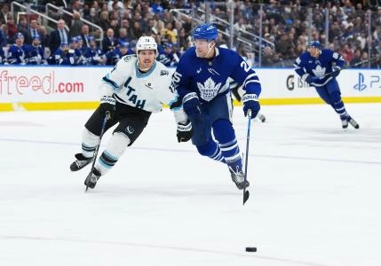 Nov 5, 2025; Toronto, Ontario, CAN; Toronto Maple Leafs defenseman Brandon Carlo (25) battles for the puck with Utah Mammoth left wing Brandon Tanev (13) during the second period at Scotiabank Arena.