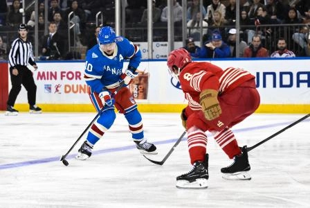 Nov 16, 2025; New York, New York, USA; New York Rangers left wing Artemi Panarin (10) skates with the puck while defended by Detroit Red Wings defenseman Ben Chiarot (8) during the third period at Madison Square Garden