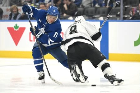 Nov 13, 2025; Toronto, Ontario, CAN; Toronto Maple Leafs forward Max Domi (11) slips the puck past Los Angeles Kings defenseman Drew Doughty (8) in the third period at Scotiabank Arena.