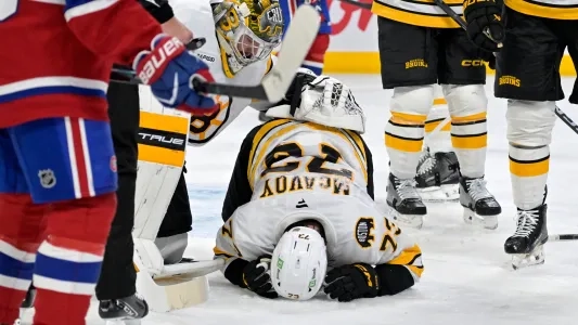 Boston Bruins' Charlie McAvoy down on the ice after getting a puck to the face
