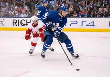 Dec 21, 2019; Toronto, Ontario, CAN; Toronto Maple Leafs defenceman Travis Dermott (23) battles for a puck with Detroit Red Wings centre Dylan Larkin (71) during the second period at Scotiabank Arena.