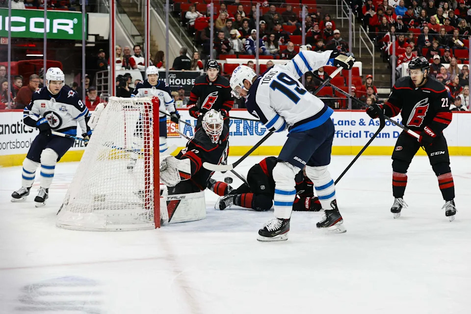 Hurricanes goalie Brandon Bussi tracks the puck as Jonathan Toews (19) of the Winnipeg Jets tries for a shot on goal during the third period at Lenovo Center on Nov. 28, 2025 in Raleigh, North Carolina.