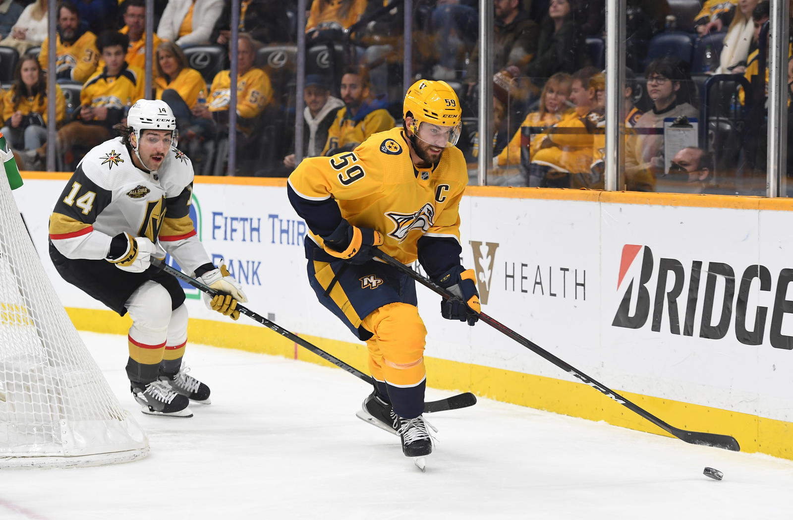 Nov 24, 2021; Nashville, Tennessee, USA; Nashville Predators defenseman Roman Josi (59) handles the puck behind the net against Vegas Golden Knights defenseman Nicolas Hague (14) during the third period at Bridgestone Arena. Mandatory Credit: Christopher Hanewinckel-Imagn Images