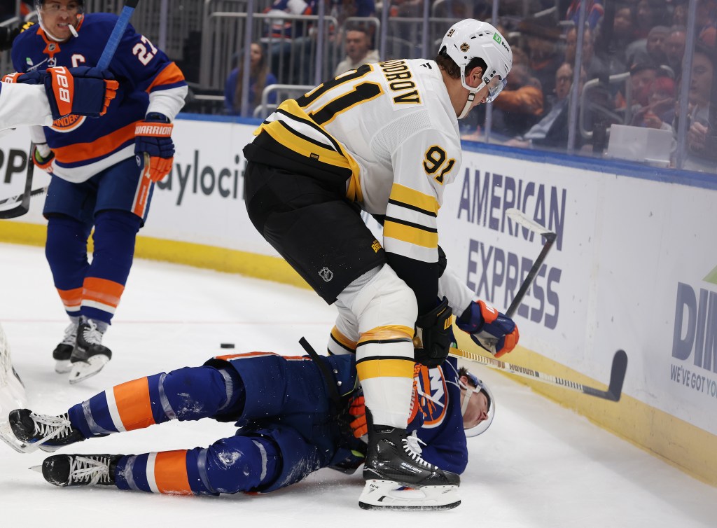 Nikita Zadorov of the Boston Bruins checks Matthew Schaefer of the New York Islanders during a hockey game.