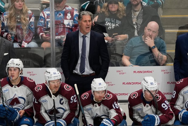 Colorado Avalanche head coach Jared Bednar, standing, reacts from the bench during the third period of an NHL hockey game against the San Jose Sharks in San Jose, Calif., Saturday, Nov. 1, 2025. Sitting in the bottom left corner is Taylor Makar. (AP Photo/Jeff Chiu)