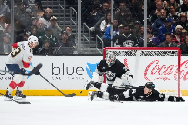 Kings defenseman Mikey Anderson, right, dives in front of a...