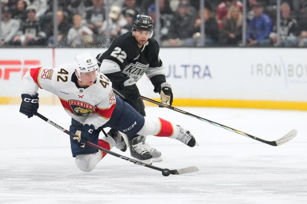 Florida Panthers defenseman Gustav Forsling, left, falls as he passes...