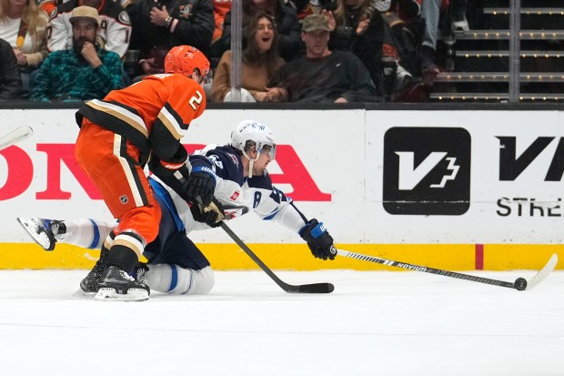 Winnipeg Jets center Mark Scheifelem right, reaches for the puck...