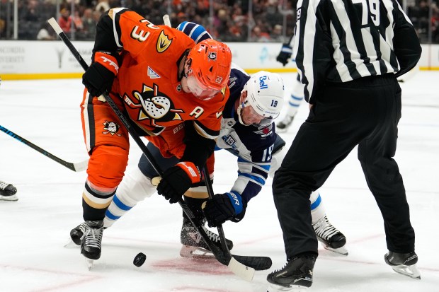 Ducks center Mason McTavish, left, and Winnipeg Jets center Jonathan...