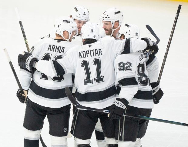 Kings’ Joel Edmundson, top right, celebrates with teammates Brandt Clarke...