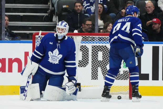 Toronto Maple Leafs goaltender Dennis Hildeby, left, and Morgan Rielly...