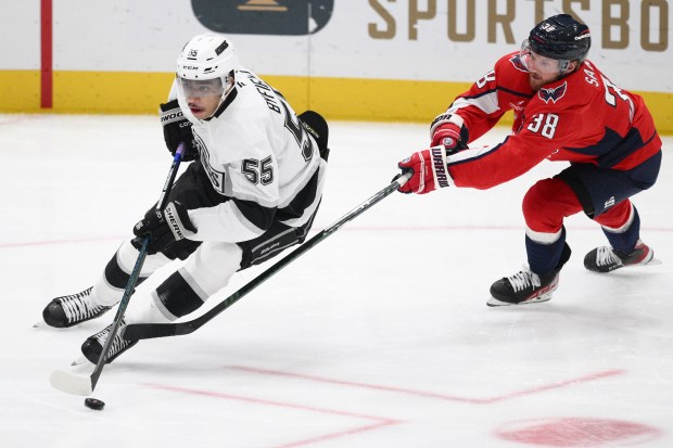 Kings right wing Quinton Byfield, left, skates with the puck...