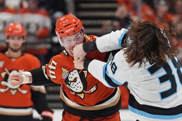 Ducks left wing Ross Johnston, left, fights Utah Mammoth center...