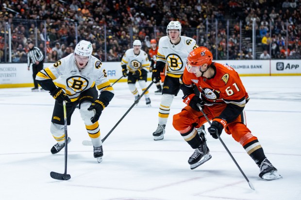 Boston Bruins defenseman Mason Lohrei, left, and Ducks left wing...