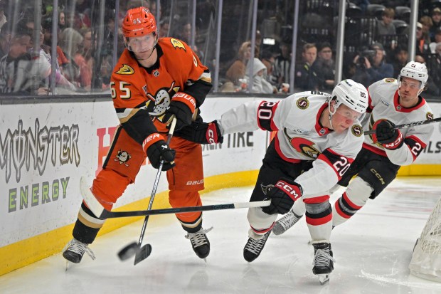 Ducks defenseman Jacob Trouba, left, passes the puck away from...