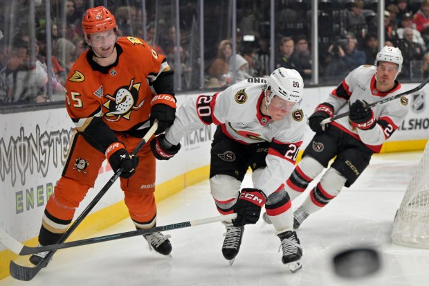 Ducks defenseman Jacob Trouba, left, passes the puck away from...