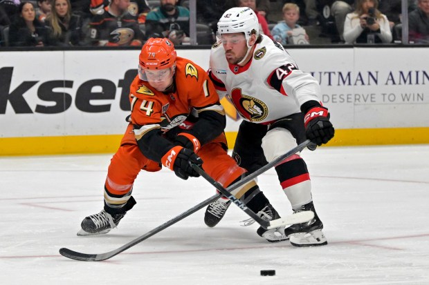 Ducks defenseman Ian Moore (74) and Ottawa Senators right wing...