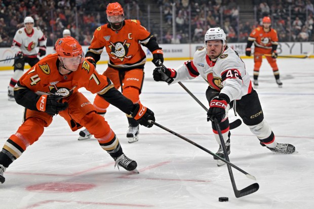 Ducks defenseman Ian Moore (74) and Ottawa Senators right wing...