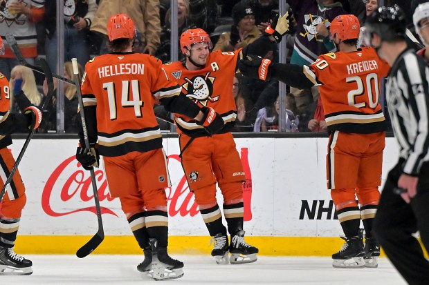 Ducks center Mason McTavish, center, is congratulated by defenseman Drew...