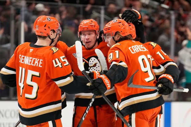 Anaheim Ducks defenseman Jackson LaCombe, center, celebrates his goal with...
