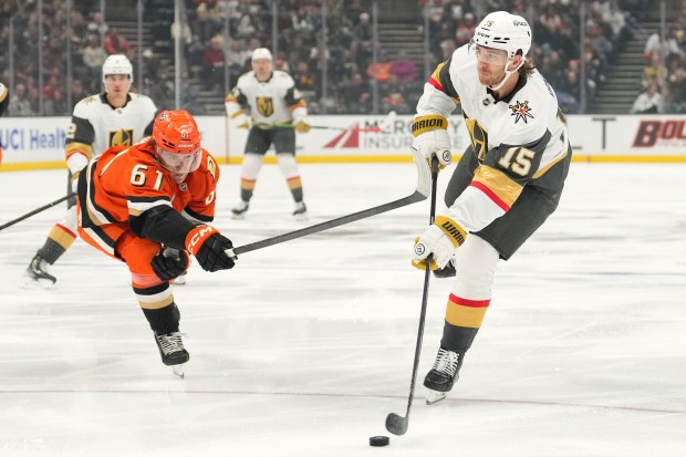 Vegas Golden Knights defenseman Noah Hanifin, right, tries to pass...
