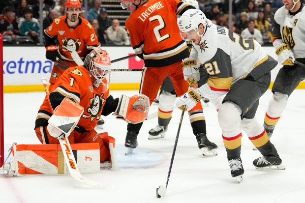 Vegas Golden Knights center Brett Howden, right, tries to get...