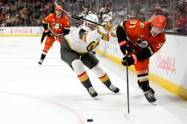 Anaheim Ducks center Leo Carlsson, right, passes the puck while...