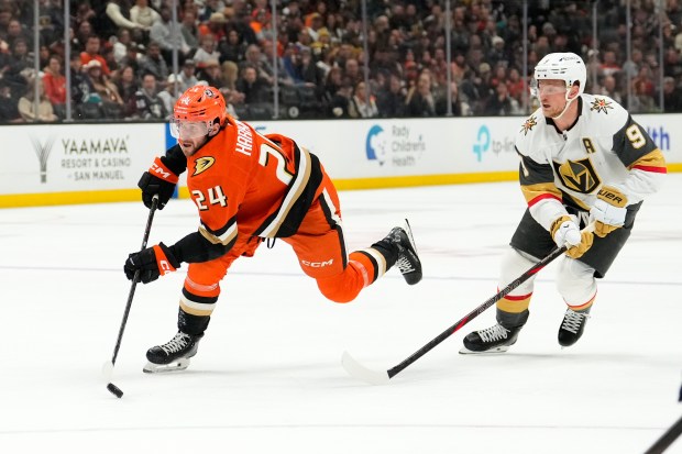 Anaheim Ducks center Jansen Harkins, left, skates with the puck...
